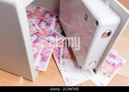 Heimischer Safe auf Dielen sitzen und überfüllt mit britischen 50 Pfund Noten. Stockfoto