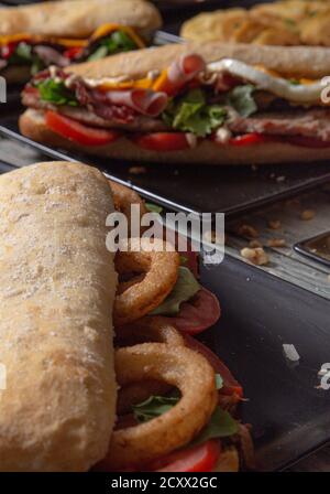 Geschlossenes Bild von Sandwiches auf Holztisch mit verschiedenen Zutaten Und Aromen Stockfoto