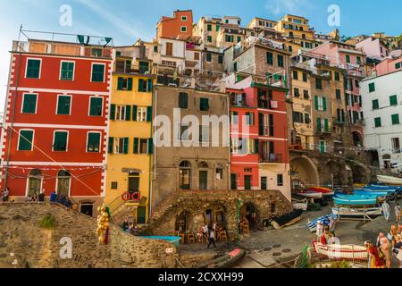 Herrliche Aussicht auf die bunten historischen Turmhäuser auf den Felsen am Kai im Zentrum von Riomaggiore in der Küstenregion Cinque Terre. Besucher... Stockfoto