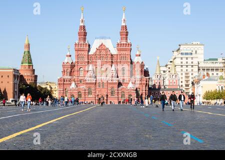 MOSKAU, RUSSLAND - 27. SEPTEMBER 2020: Touristen zu Fuß in der Nähe des Staatlichen Historischen Museums auf dem Roten Platz des Kremls in Moskau Stadt von der Morgensonne beleuchtet Stockfoto