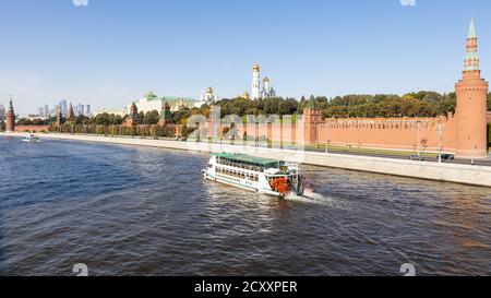 MOSKAU, RUSSLAND - 27. SEPTEMBER 2020: Panoramablick auf den Fluss Moskwa mit Ausflugsboot in der Nähe der Kremlmauern am Ufer von Bolschoj Moskvoretsky-Römerbrücke Stockfoto
