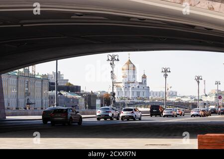 MOSKAU, RUSSLAND - 27. SEPTEMBER 2020: Autoverkehr am Kremlufer unter der Bolschoj Moskworetski Brücke und Blick auf die Kathedrale Christi des Erlösers i. Stockfoto