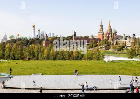 MOSKAU, RUSSLAND - 27. SEPTEMBER 2020: Touristen auf hölzernen Szene des Grand Amphitheatre in Zaryadye Stadtlandschaft öffentlichen Park und Blick auf Kremltürme Stockfoto
