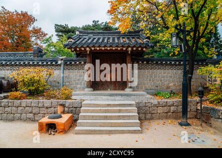 Koreanische traditionelle Tür mit herbstlichen Ahornblättern im Namsangol Hanok Village in Seoul, Korea Stockfoto