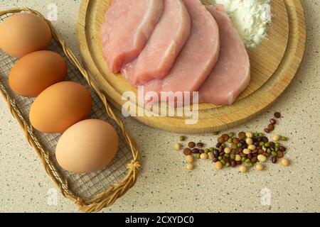 Schweinelende auf einem Brett, Weißmehl, Eier und Gewürze Stockfoto