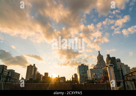 Die Sonne untergeht unter den East Village Gebäuden in New York City. Stockfoto