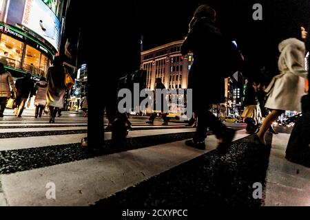 Tokyo, Japan - 14. Januar 2010: Fußgänger überqueren der Straße im Herzen von Ginza in Tokio. Ginza Kreuzung bei Nacht. Verschwommene Bewegung. Stockfoto