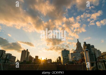 Die Sonne untergeht unter den East Village Gebäuden in New York City. Stockfoto