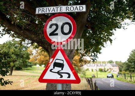 Private Straße mit einer Geschwindigkeitsbegrenzung von 20 m.p.h. Vorsicht vor rutschigem Untergrund. Stockfoto