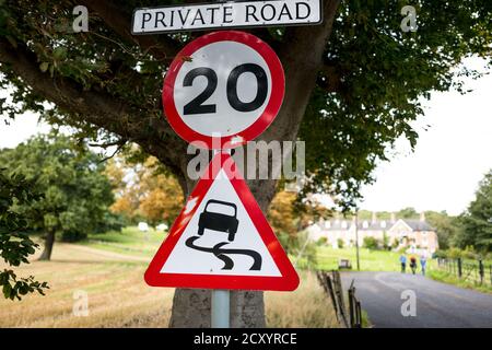 Private Straße mit einer Geschwindigkeitsbegrenzung von 20 m.p.h. Vorsicht vor rutschigem Untergrund. Stockfoto