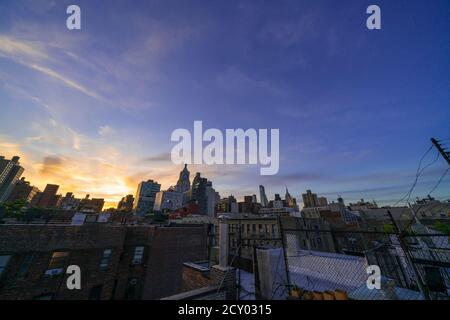 Die Sonne untergeht unter den East Village Gebäuden in New York City. Stockfoto