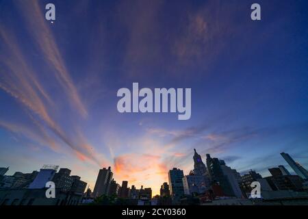 Die Sonne untergeht unter den East Village Gebäuden in New York City. Stockfoto