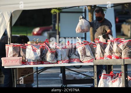 Austin, Texas, USA. Oktober 2020. Mitarbeiter führen zweimal wöchentlich eine Fresh Food-Fahrt durch, die von katholischen Wohltätigkeitsorganisationen unterstützt wird, um einkommensschwachen Texanern zu helfen, in Austin zu einem Treffen zu kommen. Die Bemühungen halfen mehreren hundert Familienmitgliedern mit Obst, Fleisch, Milch und Müsli. Kredit: Bob Daemmrich/Alamy Live Nachrichten Stockfoto