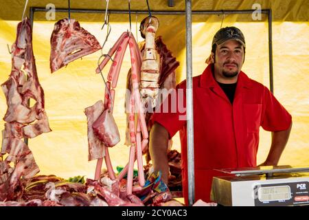 Cuenca, Ecuador, Jan 28, 2018: Der Mensch steht hinter hängen Fleisch in seinem Markt in Ecuador Abschaltdruck Stockfoto