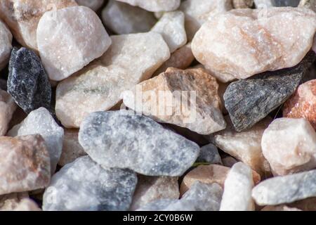 Rohe Steine und Mineralien als Natursteine Hintergrund mit zerkleinert Und das raue Material an der rauen Küste oder dem felsigen Strand Zeige Nuggets und Sandsteine Stockfoto