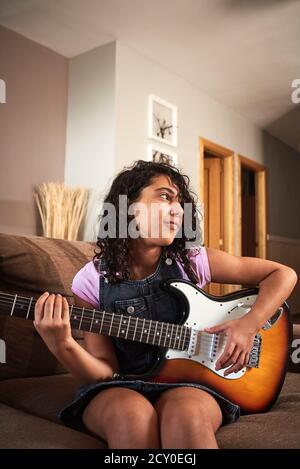 Nahaufnahme eines kleinen Mädchens, das zu Hause Gitarre spielt. Musikkonzept Stockfoto