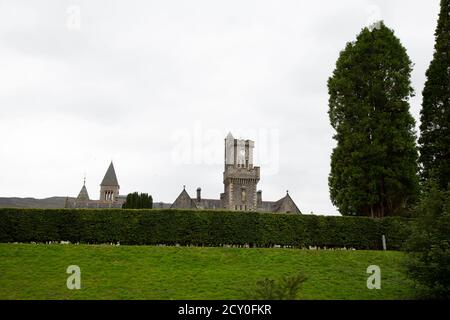 Ansicht des Klosters mit Reihe von Hecken großen Baum und Wiesenhügel Stockfoto