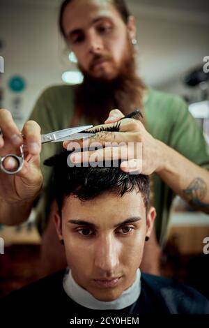 Nahaufnahme eines jungen Mannes, der seine Haare abgeschnitten hat. Friseurkonzept Stockfoto