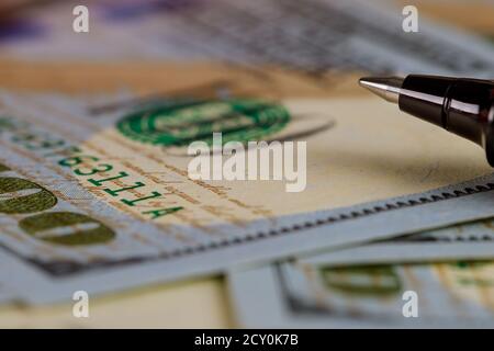 Hundert Dollar stapeln sich wie mit Kugelschreiber auf Dollar Banknoten Hintergrund Stockfoto