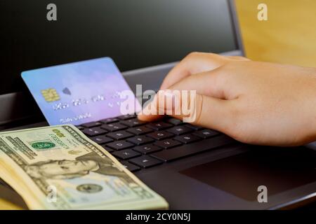 Online-Shopping Cyber Monday auf der Hand halten mit Internet Banking mit Kreditkarte für die Durchführung von Zahlungstransaktion mit Laptop Tabelle Stockfoto