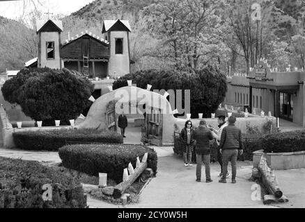 Touristen und Gläubige besuchen den historischen Santuario de Chimayo, der 1816 von adobe in dem kleinen hispanischen Dorf Chimayo, New Mexico, USA gebaut wurde. Stockfoto