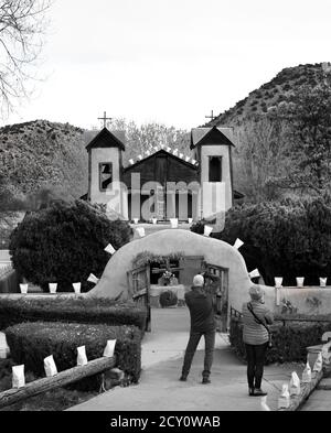 Touristen und Gläubige besuchen den historischen Santuario de Chimayo, der 1816 von adobe in dem kleinen hispanischen Dorf Chimayo, New Mexico, USA gebaut wurde. Stockfoto