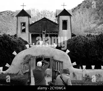 Touristen und Gläubige besuchen den historischen Santuario de Chimayo, der 1816 von adobe in dem kleinen hispanischen Dorf Chimayo, New Mexico, USA gebaut wurde. Stockfoto