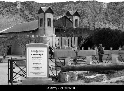 Touristen und Gläubige besuchen den historischen Santuario de Chimayo, der 1816 von adobe in dem kleinen hispanischen Dorf Chimayo, New Mexico, USA gebaut wurde. Stockfoto