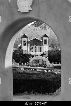 Touristen und Gläubige besuchen den historischen Santuario de Chimayo, der 1816 von adobe in dem kleinen hispanischen Dorf Chimayo, New Mexico, USA gebaut wurde. Stockfoto