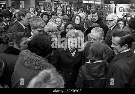 AJAXNETPHOTO, 11. FEBRUAR 1977. PORTSMOUTH, ENGLAND. - RUNDGANG DURCH DIE STADT - FRAU MARGARET THATCHER (CON), OPPOSITIONSFÜHRERIN, SETZT SICH WÄHREND EINER WAHLKAMPFTOUR MIT DER ÖFFENTLICHKEIT IM EINKAUFSVIERTEL DER HANDELSSTRASSEN AUSEINANDER. FOTO: JONATHAN EASTLAND/AJAX REF:3771102 47 Stockfoto