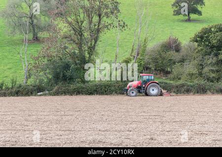 Roter tschechischer Zetor Traktor / Forterra 140 HSX Bodenbearbeitungsfeld mit spiralförmiger Krümelwalze hinter Traktor. Unsicher, ob auch Zinken kultiviert werden. Stockfoto