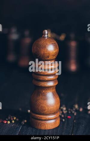 Pfeffer oder Kaffee vintage Holzmühle auf einem dunkelschwarzen Hintergrund. Stockfoto