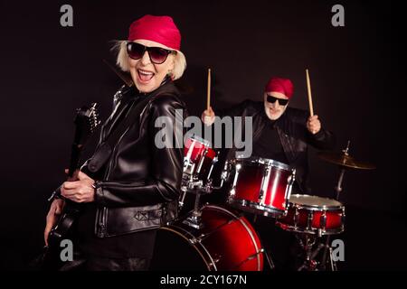 Foto von zwei pensionierten Dame Mann Rock populäre Band auftreten Konzert spielen Schlagzeug Instrumente Solo Gitarre Familienbetrieb tragen trendy Outfit aus Rockerleder Stockfoto