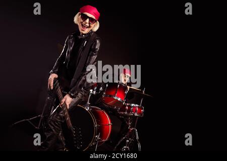 Foto von zwei pensionierten Dame Mann Rock populäre Band auftreten Konzert spielen Schlagzeug Instrumente Solo Gitarre Familienbetrieb tragen trendy Outfit aus Rockerleder Stockfoto