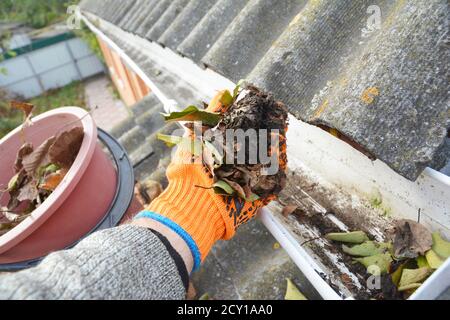 Tipps Zur Reinigung Der Dachrinne. Reinigen Sie Ihre Dachrinnen. Rinne Reinigung von Blättern. Stockfoto