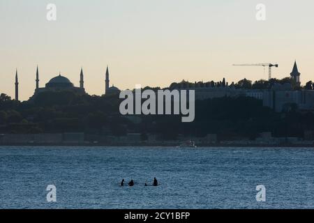 Istanbul, Türkei - 1. September 2020: Vier Männer stehen mitten im Istanbuler Bosporus auf und das sieht seltsam aus. Die Hagia Sophia Stockfoto