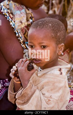 Porträt eines kleinen Kindes essen, die Hadza, oder Hadzabe - sind eine indigene ethnische Gruppe in Nord-Zentral-Tansania Stockfoto