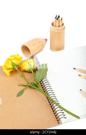 Buntstifte, Hefte und Rosenblumen isoliert auf weißem Hintergrund. Stockfoto