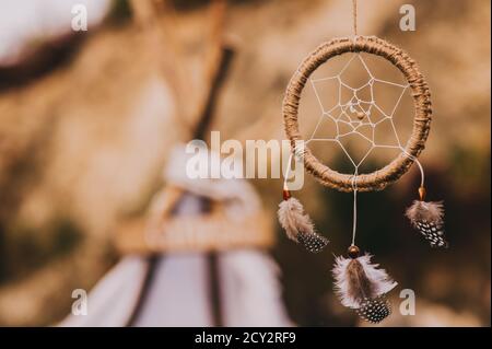 Nahaufnahme des Traumfängers auf verschwommenem Hintergrund bei abendlicher Sonneneinstrahlung in Vintage-Farben. Stockfoto