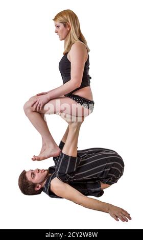 Junges Paar Praktiken Akrobatik Balance mit Frau sitzt auf der Mann s upstretched Beine. Stockfoto