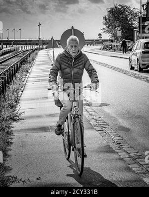 HELSINGOR, DÄNEMARK - 05. SEPTEMBER 2020: Eine Rentnerin radelt mit ihrem Fahrrad durch die Straßen der Stadt. Stockfoto