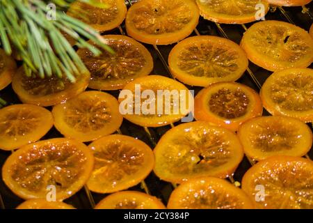 Getrocknete Orangen und Kiefer Zweig. Prozess der Vorbereitung von orange kandierten Früchten für Neujahr und Weihnachtsfeier. Vorderansicht Stockfoto