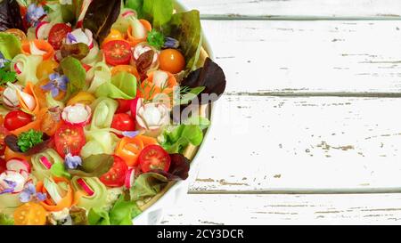 Cold Pie - Weichkäse und frisches Gemüse: Radieschen, Tomaten, Gurken, Zwiebeln, grüner Salat mit Petersilie und Burashblumen auf einem weißen Holz dekoriert Stockfoto