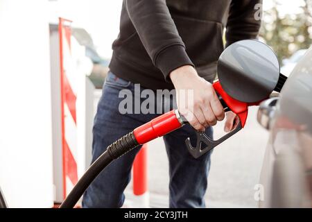Transport und Eigentümerkonzept - Mann Pumpen Benzin Kraftstoff im Auto an Tankstelle Stockfoto