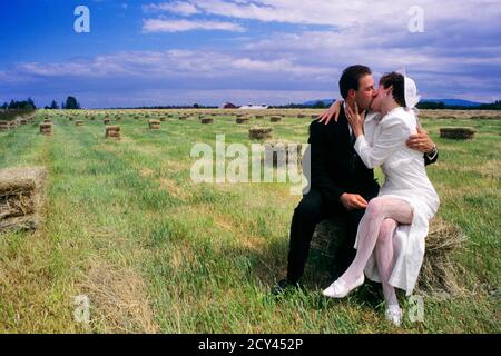 NEUNZIGERS NEWLYWED MANN FRAU BRAUT BRÄUTIGAM MANN FRAU SITZEN KÜSSEN UMARMUNG AM BAY BALE IN HAYFIELD EASTERN WASHINGTON STATE USA - KB31148 LGA001 HARS ZUKUNFT NOSTALGIE UMARMUNG ALTE MODE 1 JUNGE ERWACHSENE HEU UMARMEN TOUCH HALS STARKE ABSTRAKTE FREUDE LIFESTYLE FEIER FRAUEN VERHEIRATET LÄNDLICHEN EHEGATTEN EHEMÄNNER GESUNDHEIT HORIZONTALE KOPIE RAUM FREUNDSCHAFT IN VOLLER LÄNGE UMARMUNG DAMEN EHE PERSONEN INSPIRATION FÜRSORGLICHE LANDWIRTSCHAFT MÄNNER ZEREMONIE UMARMUNG EHEMANN UND EHEFRAU PARTNER FEIERN MENSCHEN GESCHICHTE TRÄUME PASSAGE GLÜCK BAUERNHOF ERNTE UND AUFREGUNG BAUERN DER LIEBEVOLLEN VERBINDUNG KONZEPTIONELLE ZUNEIGUNG Stockfoto