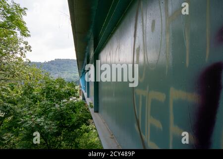 In der Nähe der Seite einer hellblauen Brücke bedeckt In Graffiti Stockfoto