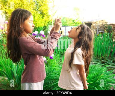 Kleines Mädchen macht einen Grimasse, während ihre ältere Schwester macht ihr Bild. Stockfoto