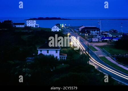 1990S AUTO SCHEINWERFER NACHTANSICHT STADT VON NEUEN SHOREHAM AUF BLOCK ISLAND RHODE ISLAND USA - KR109129 GER002 HARS MOTION BLUR RHODE OSTKÜSTE FLUCHT RI BLOCK INSEL NEUENGLAND ABENDDÄMMERUNG ALTMODISCH Stockfoto