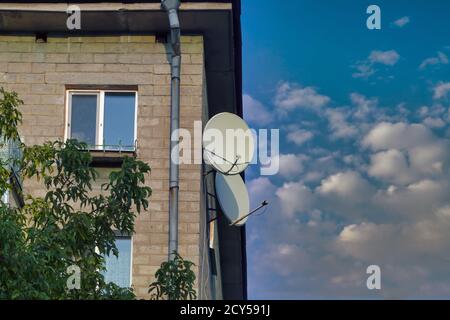 TV-Satellitenschüsseln an der Fassade eines Wohnhauses. Stockfoto