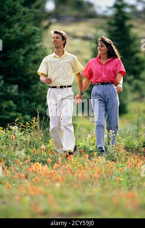 1990 MANN UND FRAU PAAR HÄNDE IN LEGERER KLEIDUNG SPAZIERGANG IM SCHREINPASS IN DER NÄHE VON VAIL COLORADO USA - KS29626 WAL004 HARS BEKLEIDUNGSGESCHICHTE NOSTALGISCHE ROMANTIK FRÜHLINGSFARBE ALTE ZEIT NOSTALGIE ALTE MODE 1 STIL GESUND WACHSENDE TEAMARBEIT FIT ZUFRIEDEN FREUDE LEBENSSTIL ZUFRIEDENHEIT FRAUEN VERHEIRATET LÄNDLICHEN EHEGATTEN EHEMÄNNER GESUNDHEIT KOPIE RAUM FREUNDSCHAFT IN VOLLER LÄNGE DAMEN PERSONEN MÄNNER VERTRAUEN PARTNER BRÜNETTE FRISCH GLÜCK WELLNESS FRÖHLICH ABENTEUER FREIZEIT UND AUFREGUNG AUSSEN NIEDRIGEN WINKEL FREIZEIT HEMDEN MANN UND FRAU HÄLT HÄNDE MENSCHEN MÄNNER OFFEN LÄCHELT LEBHAFTE VERBINDUNG FREUDIG Stockfoto